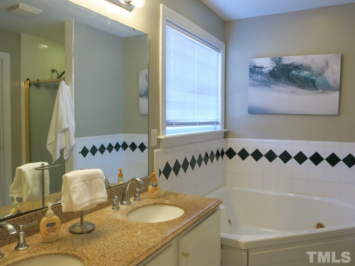 2845 Praire View Point Wendell, NC 27591 - Photo 14 of 25 The Master Bath has a tiled shower, corner jetted tub w/tiled surround, granite-topped vanity w/double sinks, tile floor & private toilet rm.