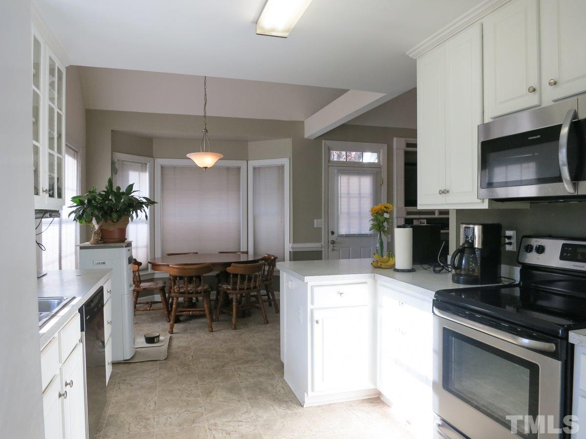 2845 Praire View Point Wendell, NC 27591 - Photo 9 of 25 The Kitchen features lots of tall white cabinets (some w/glass doors), new SS appls (smooth-top range, MW, DW), granite-look laminate ctrs, pantry & stone-look vinyl flr.