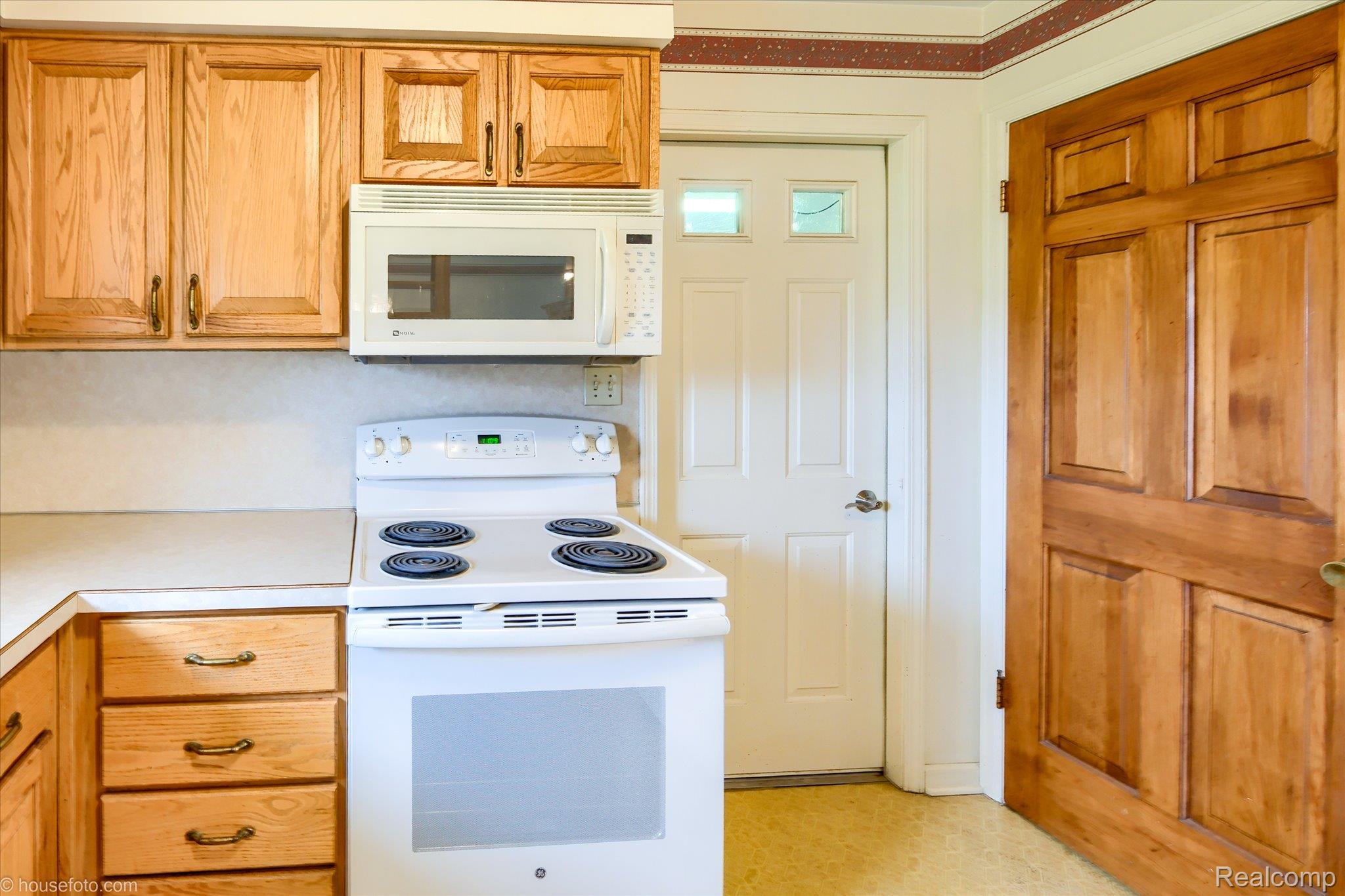 6080 Shattuck Road Saginaw, MI 48603 - Photo 17 of 35 Kitchen featuring white appliances, light countertops, and wood finish cabinets