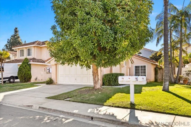 a front view of a house with a yard and potted plants