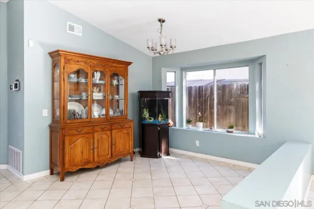 a kitchen with stainless steel appliances granite countertop a stove top oven a sink a dining table and chairs