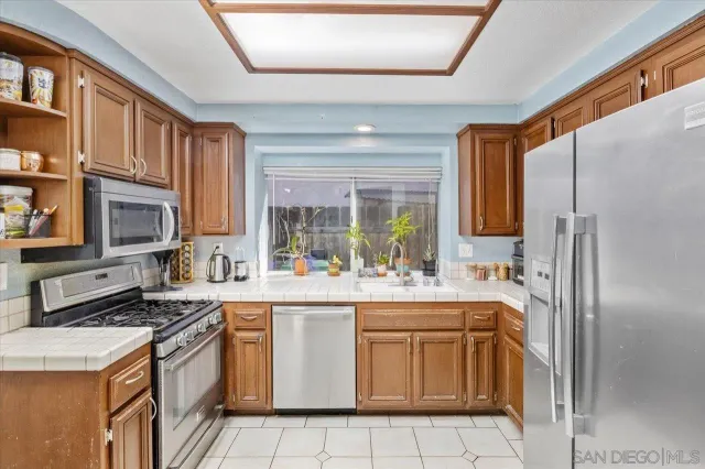 a kitchen with a sink a refrigerator and cabinets