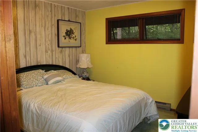 a bedroom with a bed and a painting on the wall