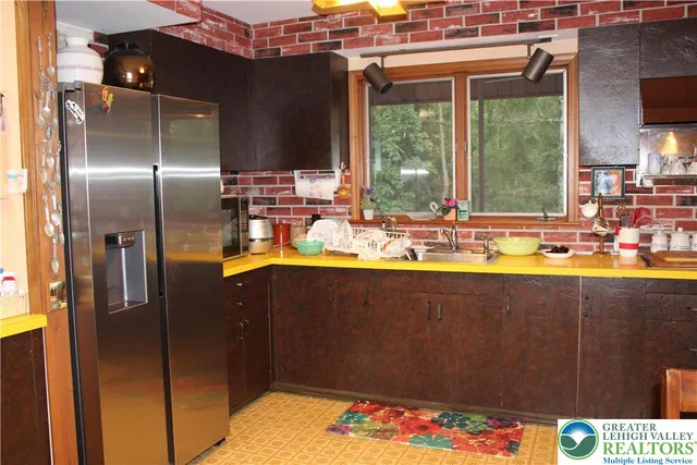 a living room with furniture a fireplace and a floor to ceiling window