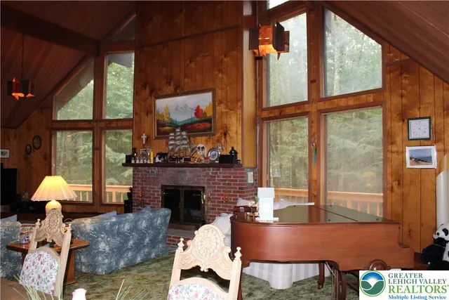 a living room with furniture a fireplace and a floor to ceiling window