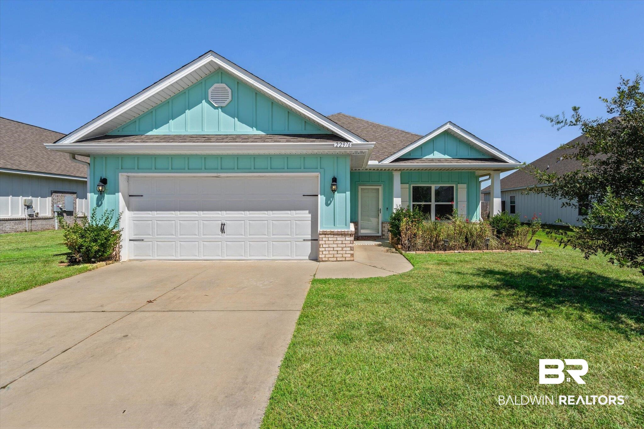 22976 Lieutenant Avenue Foley, AL 36535 - Photo 2 of 30 Ranch-style home with board and batten siding, a garage, a front lawn, concrete driveway, and roof with shingles
