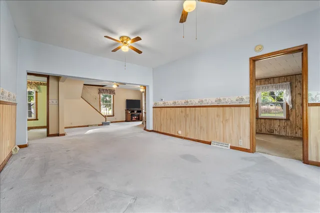 an empty room with a ceiling fan and a window