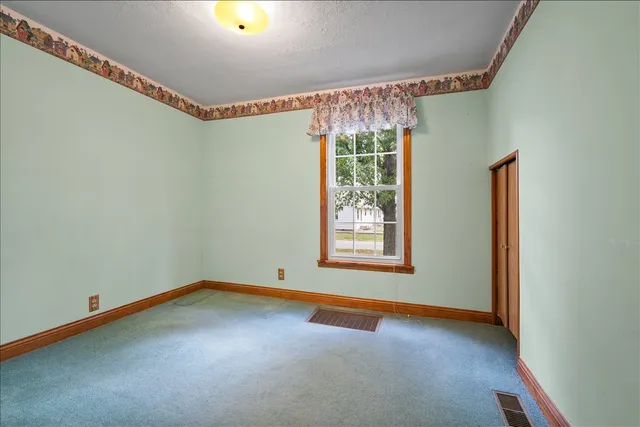 a view of a room with window and carpet