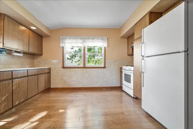 a view of kitchen with furniture and a refrigerator