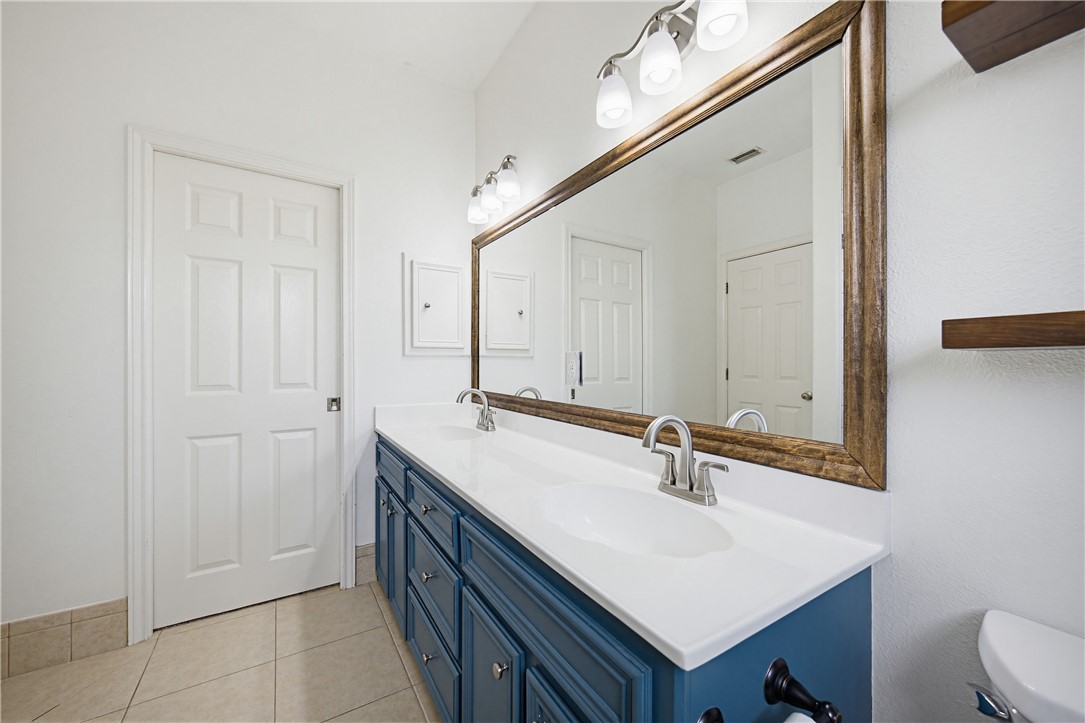 7251 Prairie Drive, Unit 6 Corpus Christi, TX 78413 - Photo 24 of 28 a bathroom with a sink a toilet and a mirror