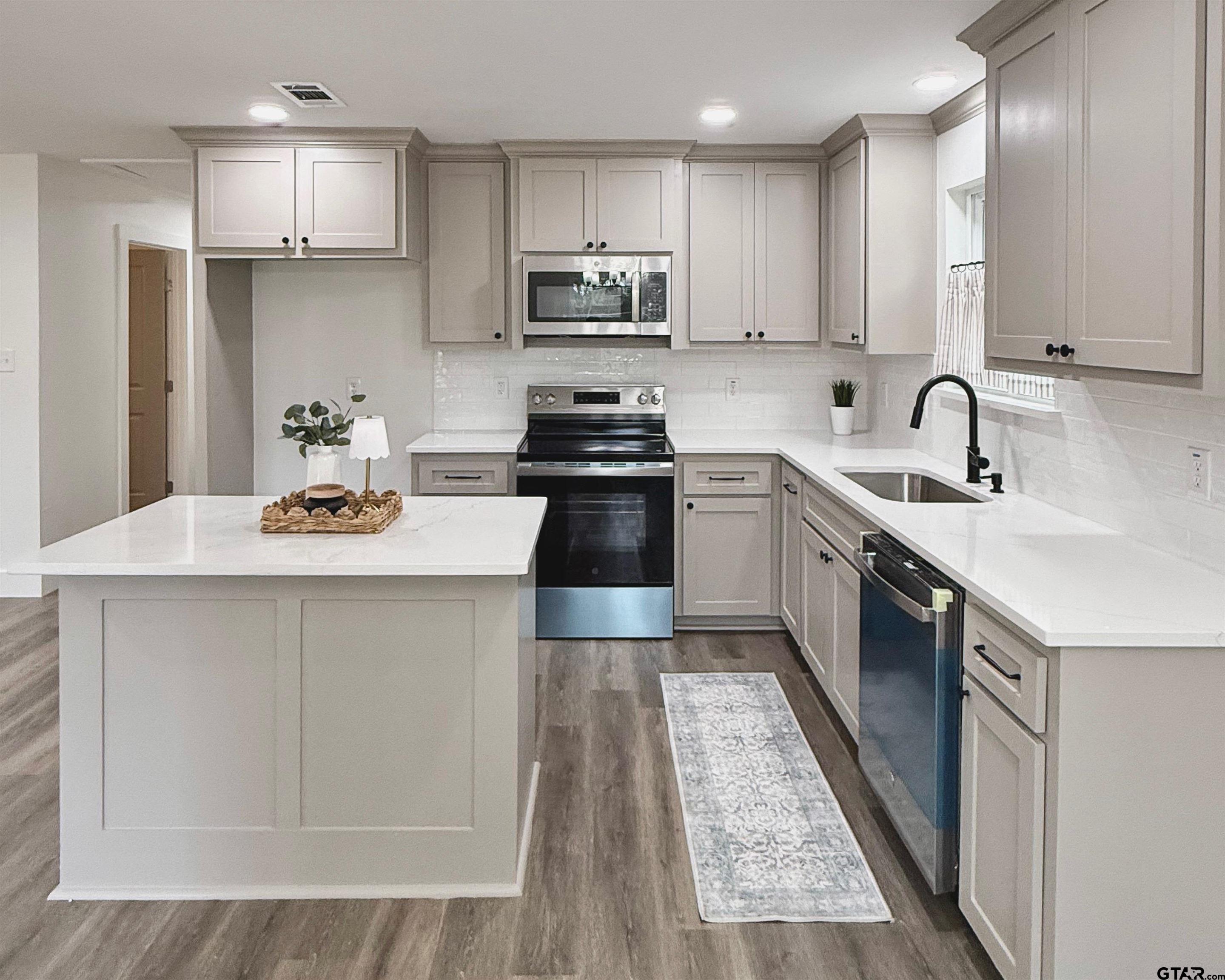 412 Garver Street Pittsburg, TX 75686 - Photo 2 of 11 a kitchen with stainless steel appliances granite countertop a sink stove refrigerator and cabinets