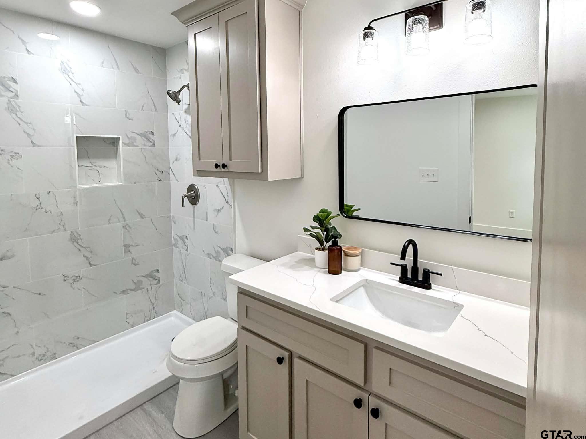 412 Garver Street Pittsburg, TX 75686 - Photo 4 of 11 a bathroom with a sink a toilet and shower