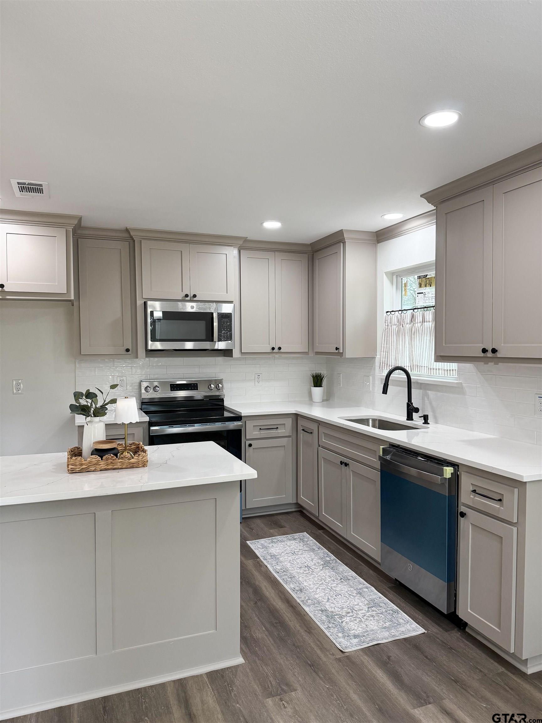 412 Garver Street Pittsburg, TX 75686 - Photo 6 of 11 a kitchen with stainless steel appliances granite countertop a sink dishwasher stove top oven and refrigerator with cabinets