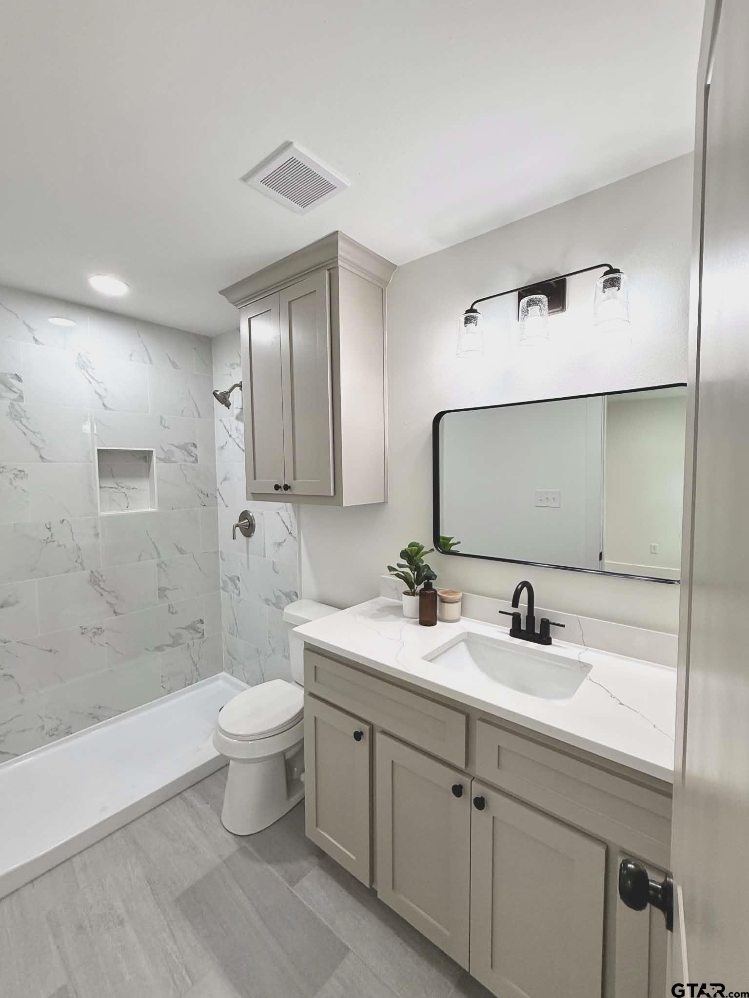 412 Garver Street Pittsburg, TX 75686 - Photo 8 of 11 a bathroom with a double vanity sink toilet mirror and shower