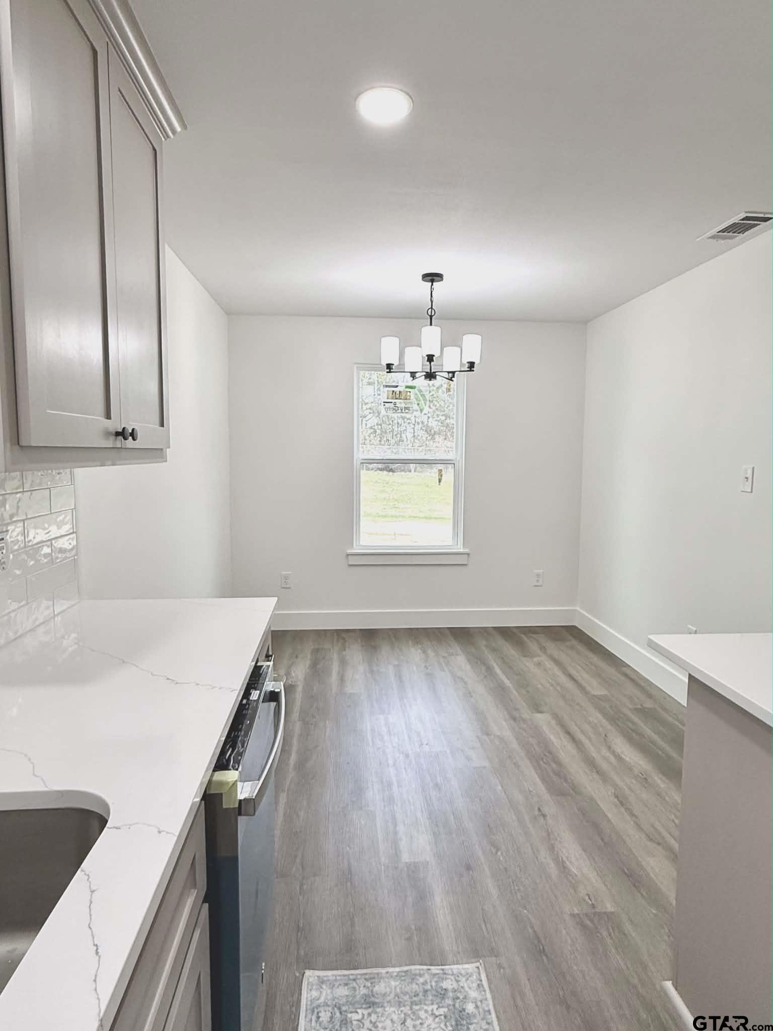 412 Garver Street Pittsburg, TX 75686 - Photo 9 of 11 a view of a kitchen with a sink and dishwasher with wooden floor