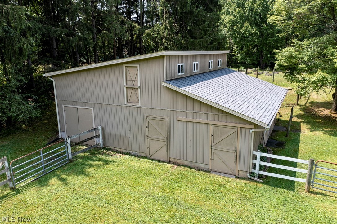 3090 Sourek Road Akron, OH 44333 - Photo 5 of 36 Two-story barn structure featuring vertical siding, a silver metal roof, and multiple access doors