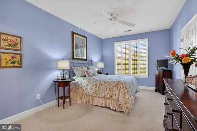a bedroom with a bed and a lamp on dresser
