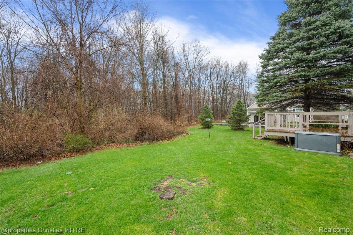955 Rikki Ann Court Wixom, MI 48393 - Photo 11 of 54 View of grassy yard featuring a deck