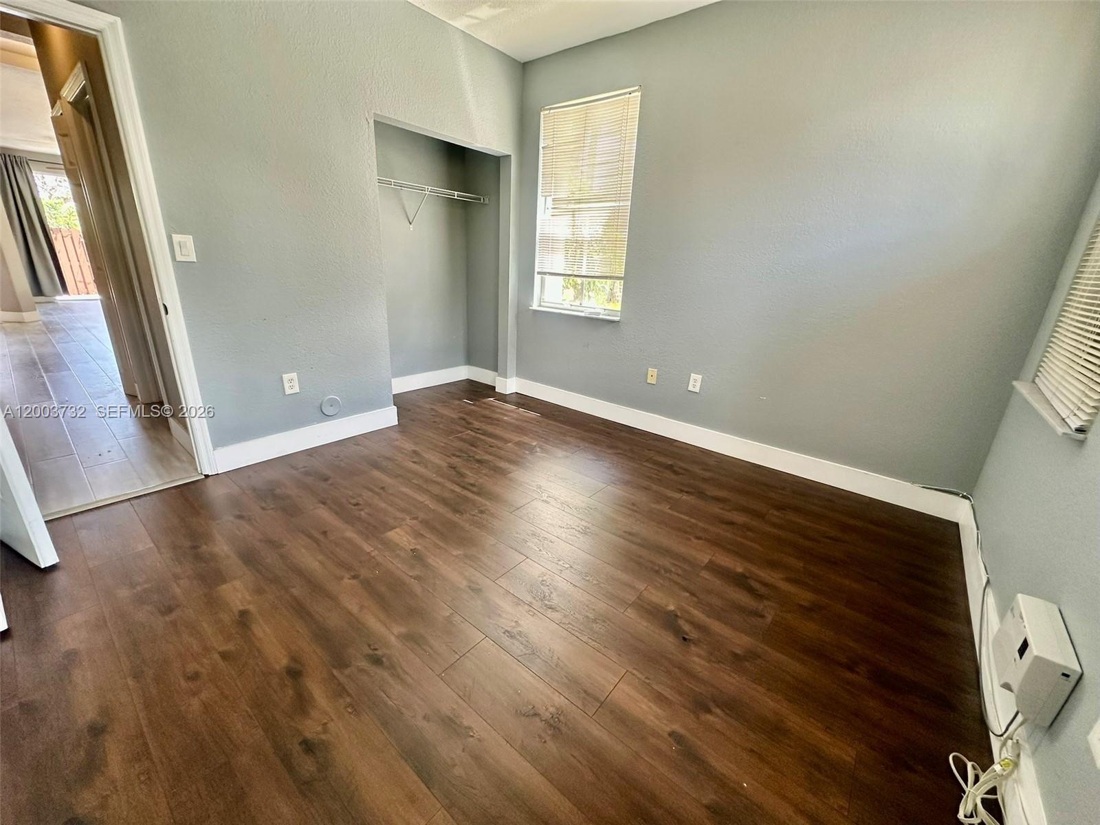 16537 Southwest 78th Terrace Miami, FL 33193 - Photo 12 of 34 a view of an empty room with wooden floor and a window