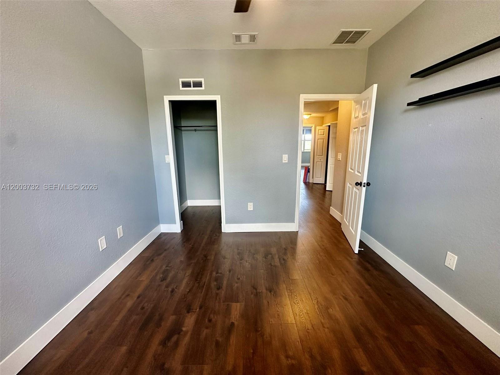 16537 Southwest 78th Terrace Miami, FL 33193 - Photo 14 of 34 a view of an empty room with wooden floor and a window
