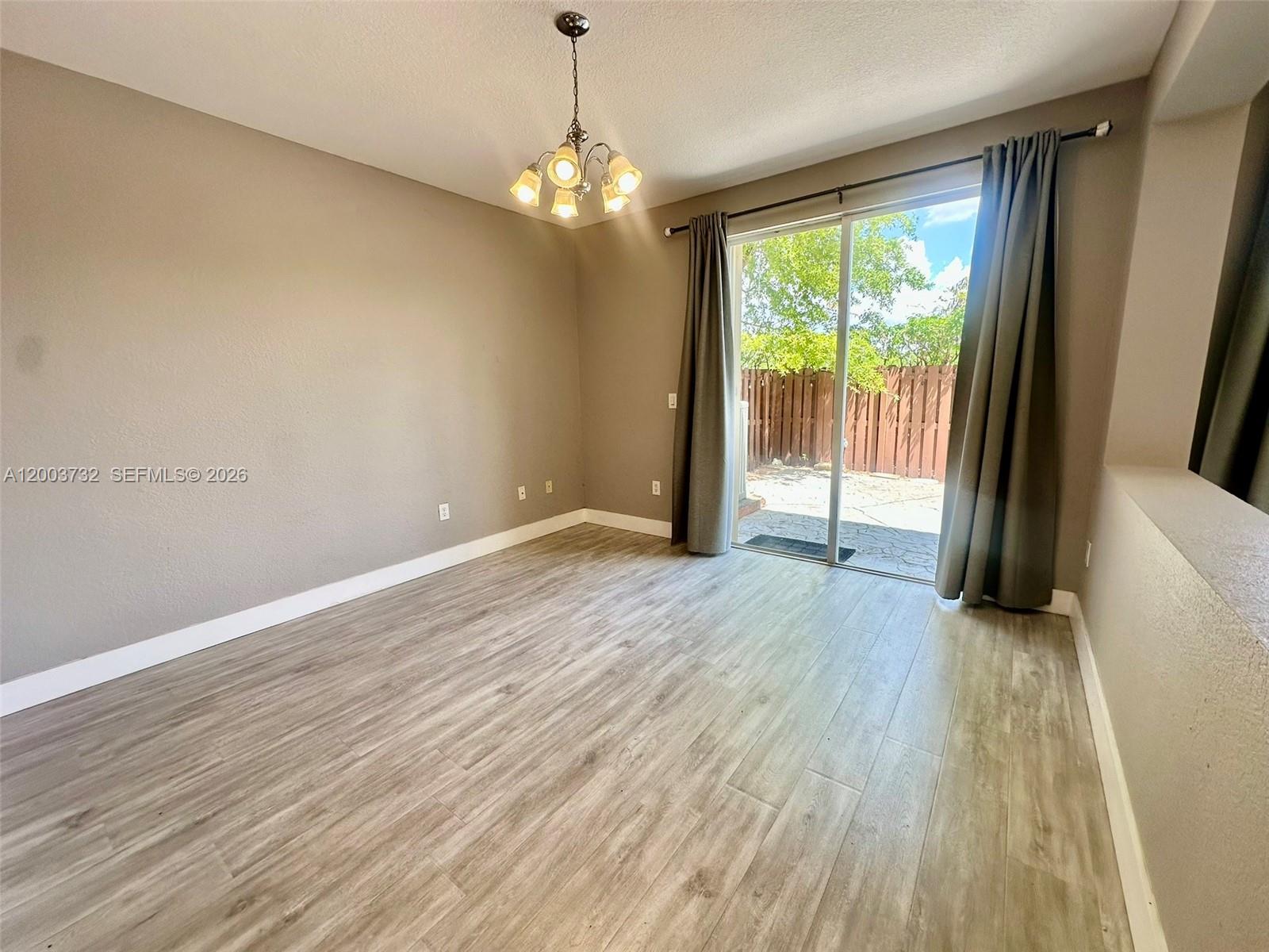 16537 Southwest 78th Terrace Miami, FL 33193 - Photo 2 of 34 a view of an empty room with wooden floor and a window