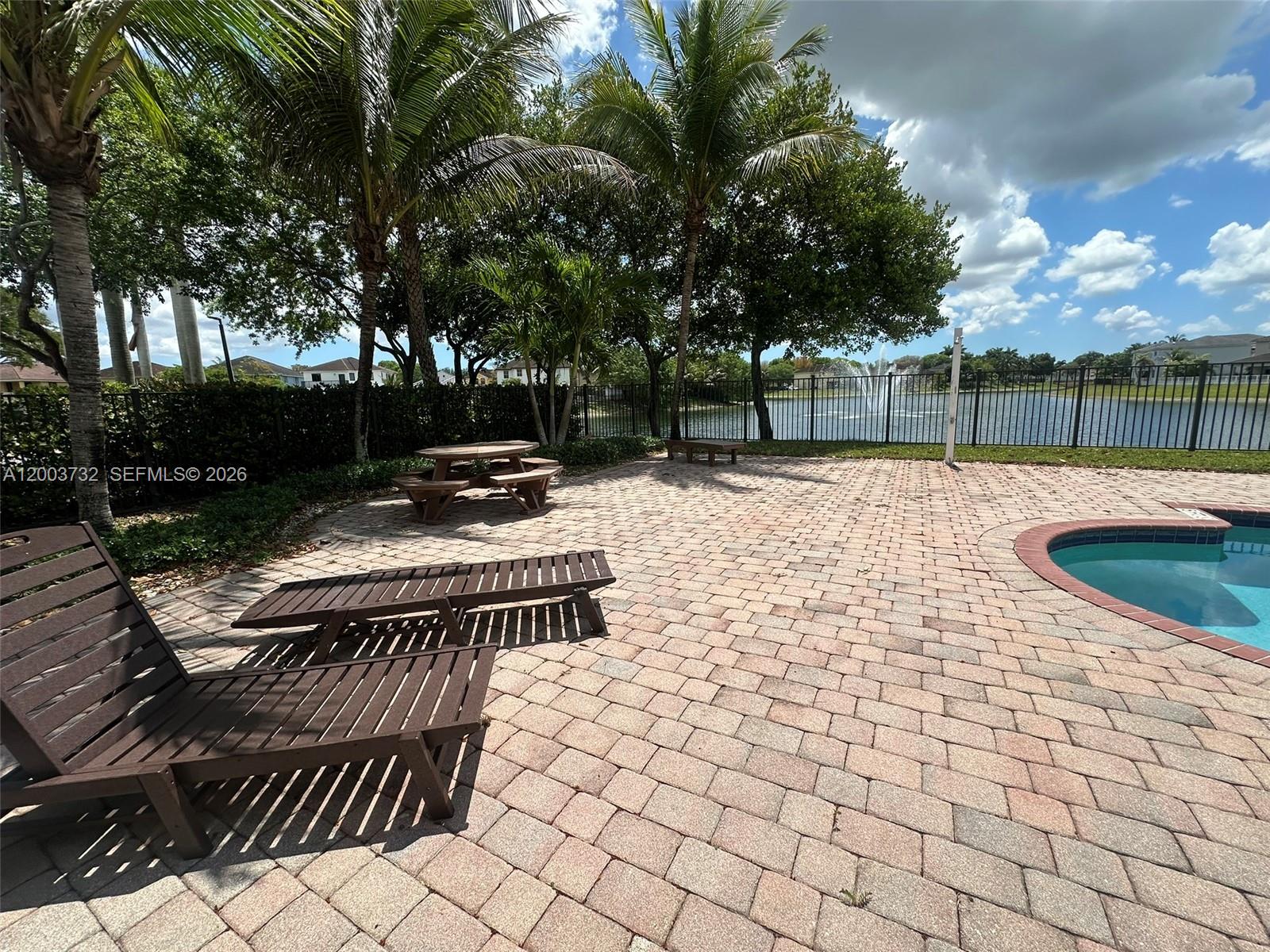 16537 Southwest 78th Terrace Miami, FL 33193 - Photo 31 of 34 a view of a patio with table and chairs with wooden fence and plants