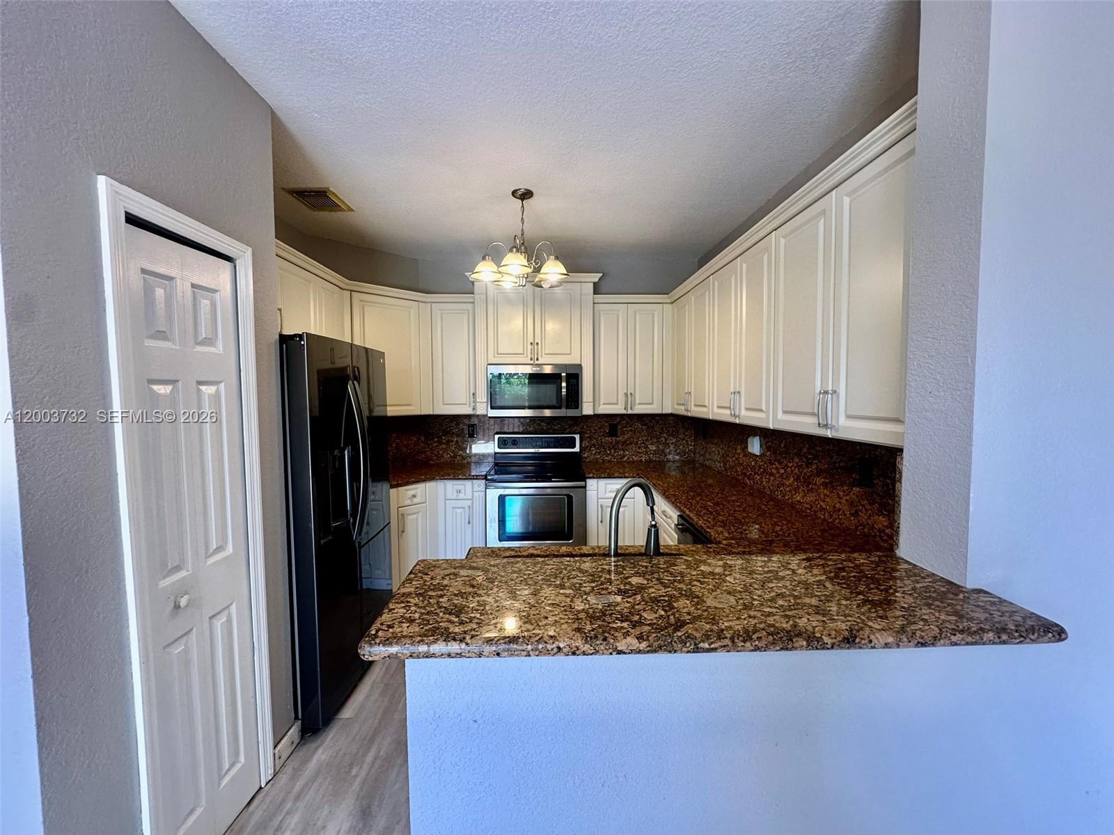 16537 Southwest 78th Terrace Miami, FL 33193 - Photo 7 of 34 a kitchen with refrigerator and cabinets