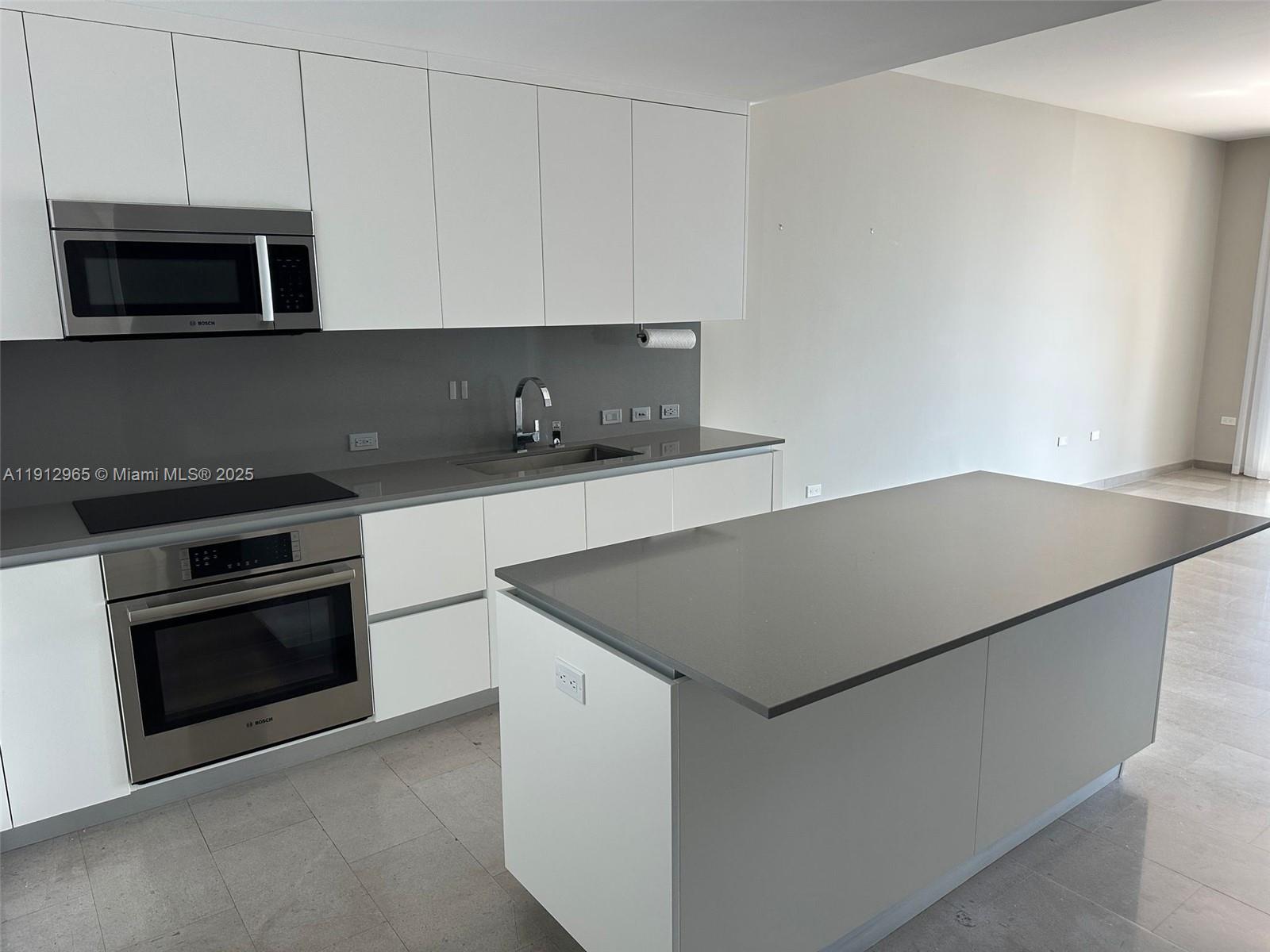 68 Southeast 6th Street, Unit 2205 Miami, FL 33131 - Photo 15 of 28 a kitchen with stainless steel appliances a stove microwave and sink
