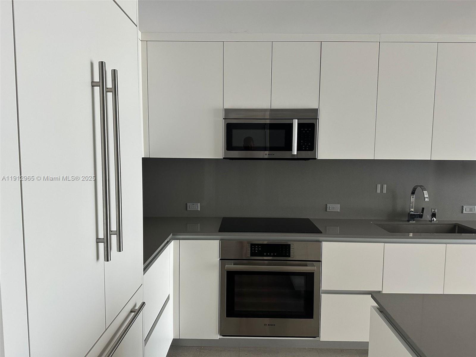 68 Southeast 6th Street, Unit 2205 Miami, FL 33131 - Photo 18 of 28 a kitchen with stainless steel appliances a stove microwave and sink