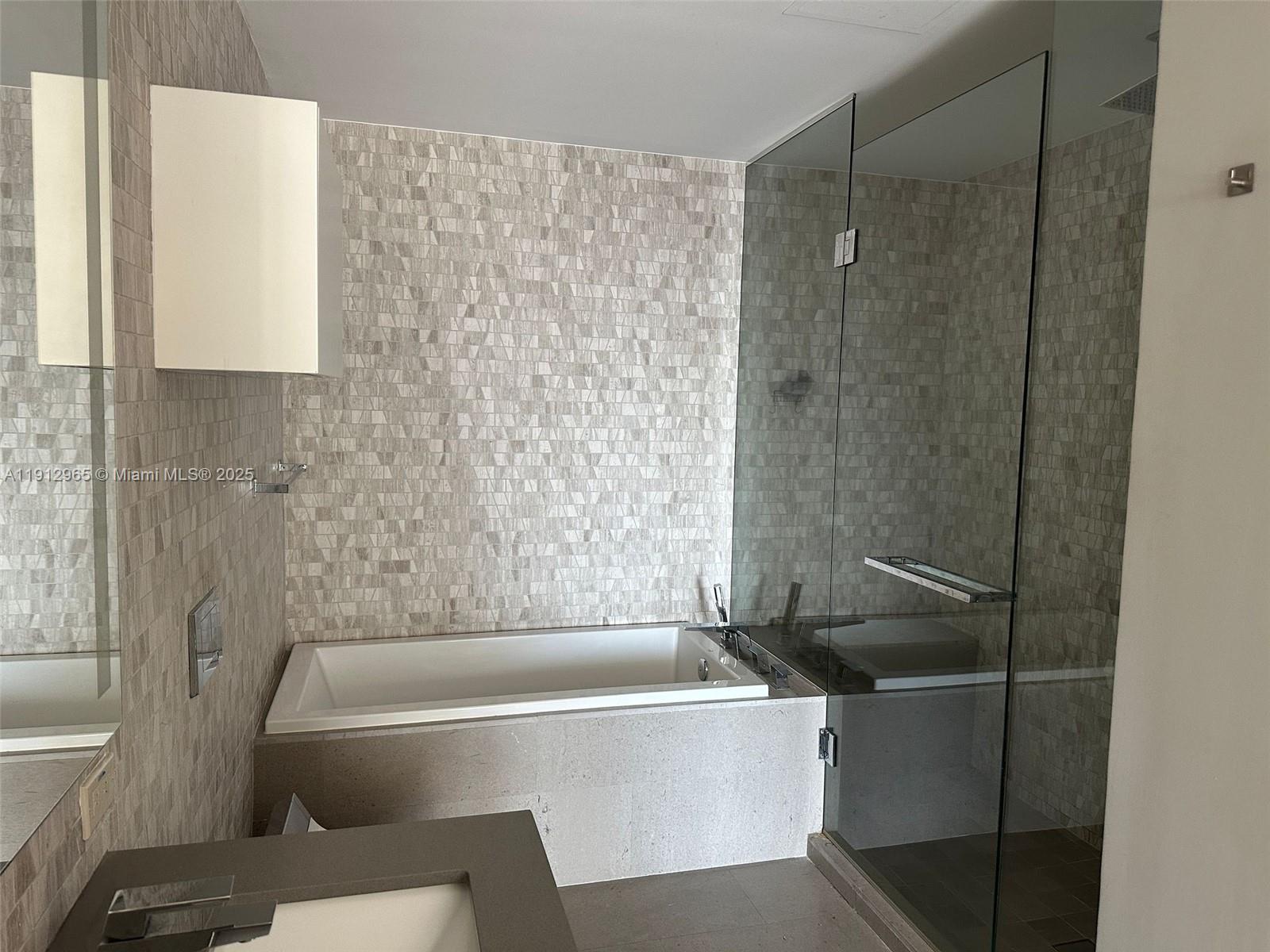 68 Southeast 6th Street, Unit 2205 Miami, FL 33131 - Photo 20 of 28 a bathroom with a bathtub and a shower