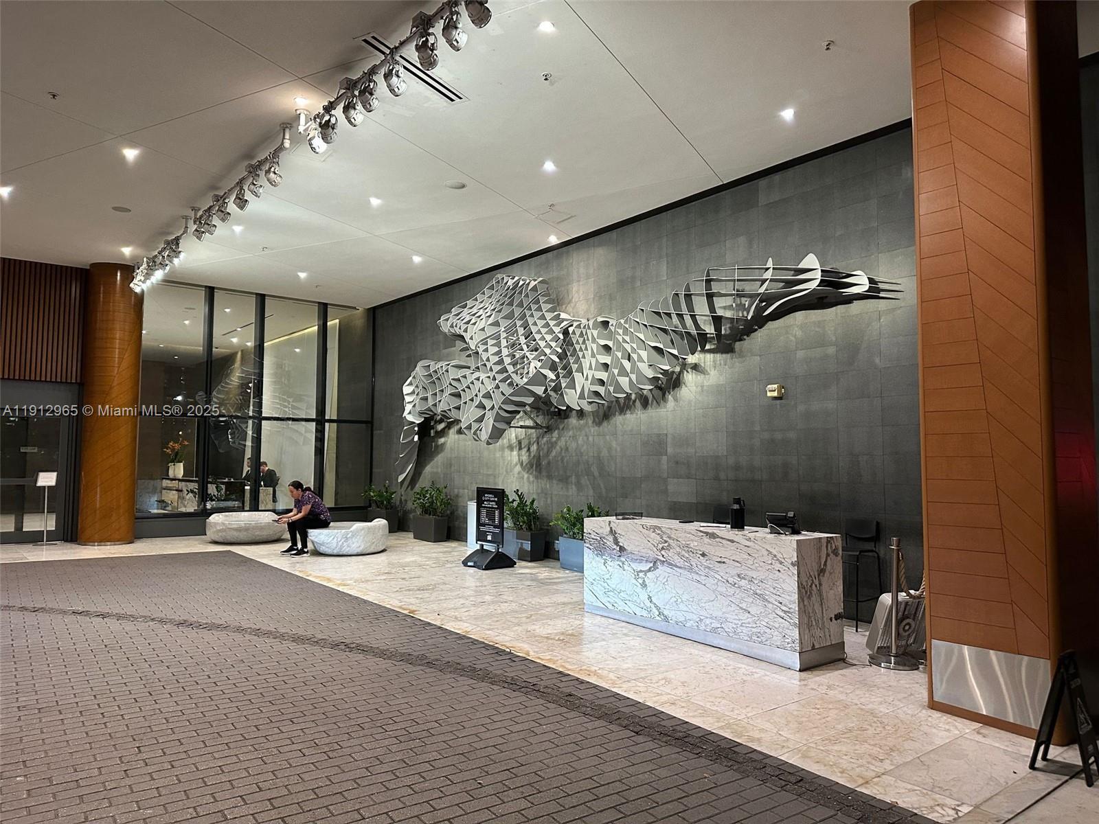 68 Southeast 6th Street, Unit 2205 Miami, FL 33131 - Photo 21 of 28 a lobby with furniture and a potted plant