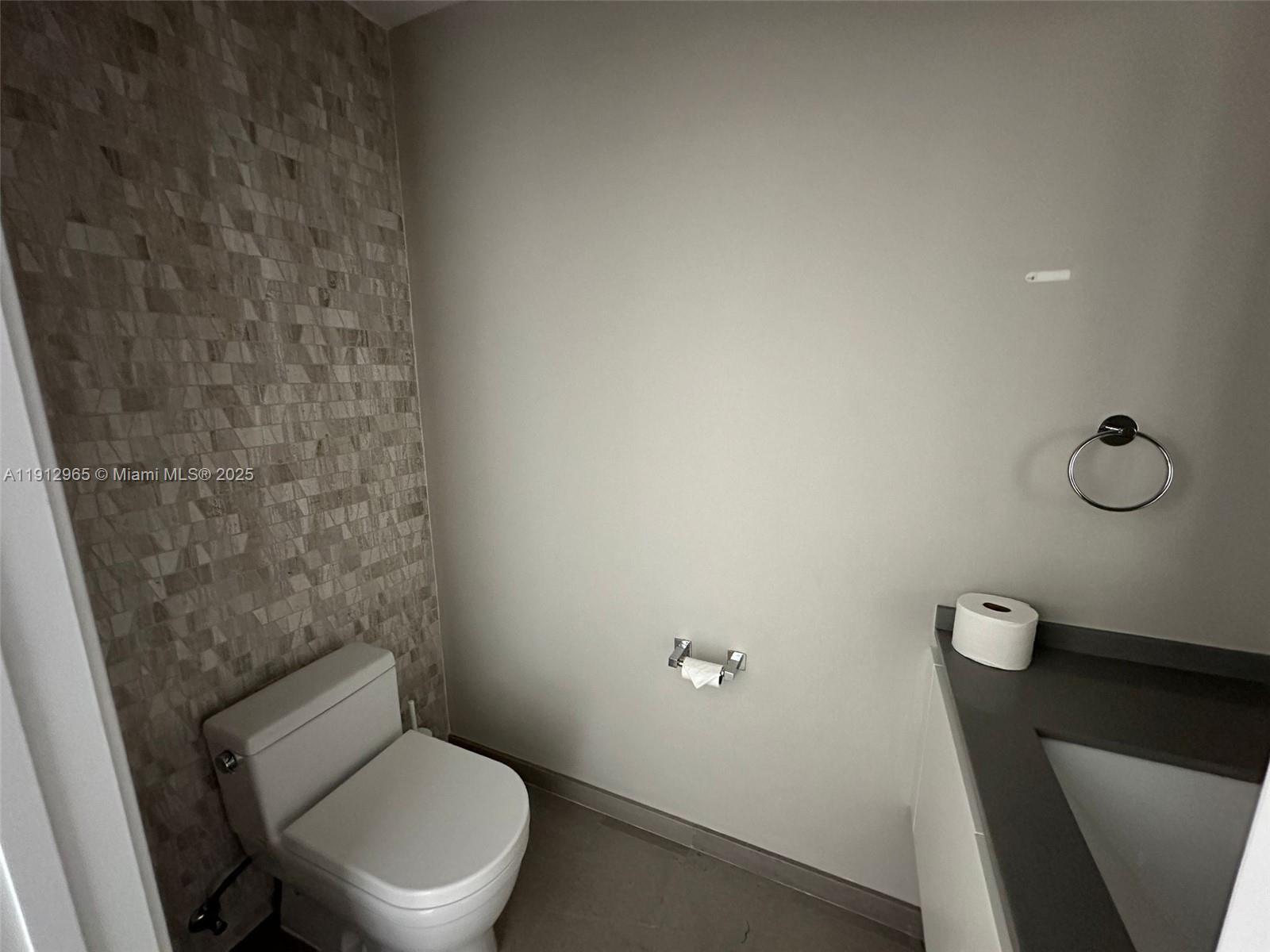 68 Southeast 6th Street, Unit 2205 Miami, FL 33131 - Photo 23 of 28 a white toilet sitting next to a shower
