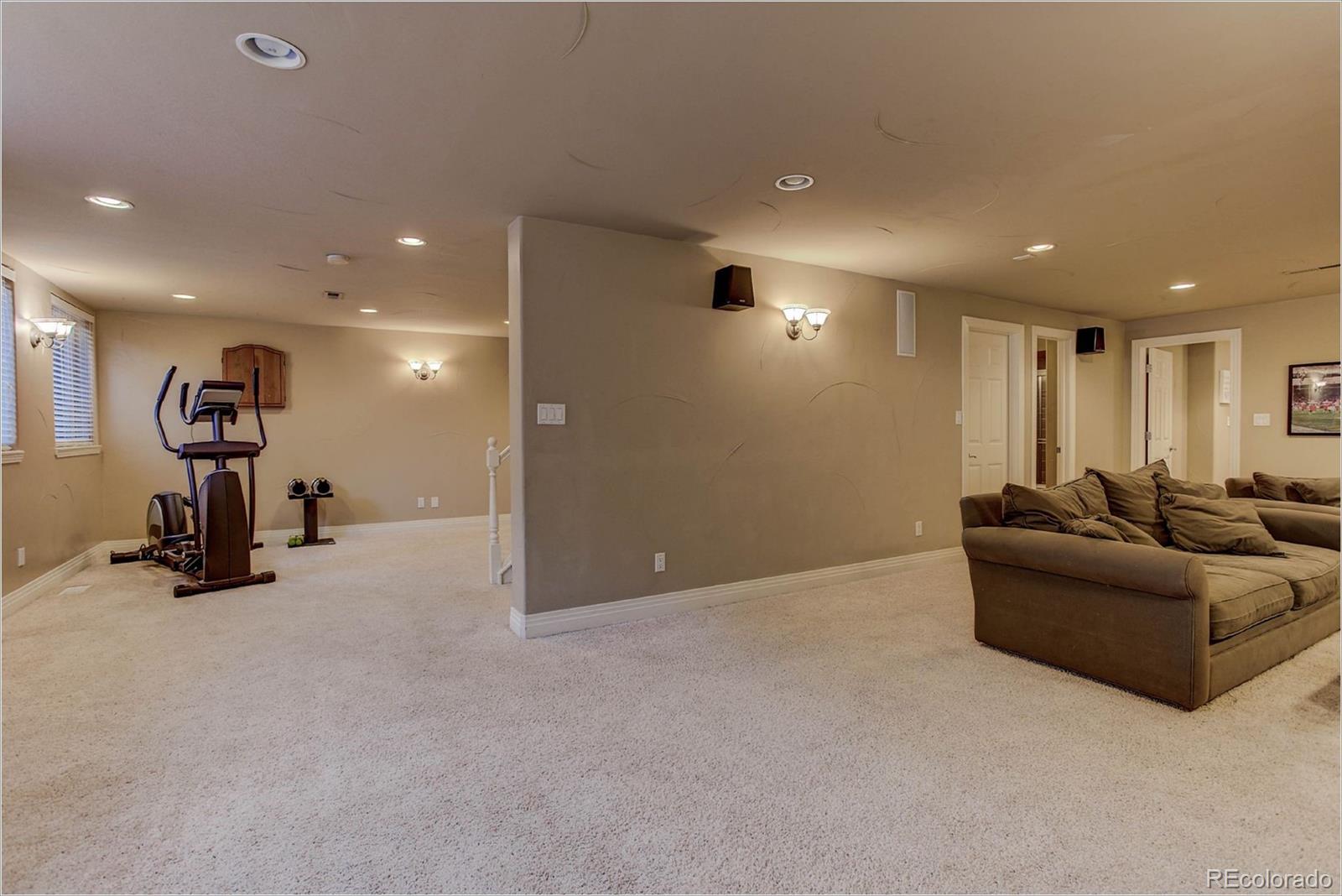 9425 South Shadow Hill Circle Lone Tree, CO 80124 - Photo 31 of 35 a living room with furniture and a gym machine with the view of kitchen
