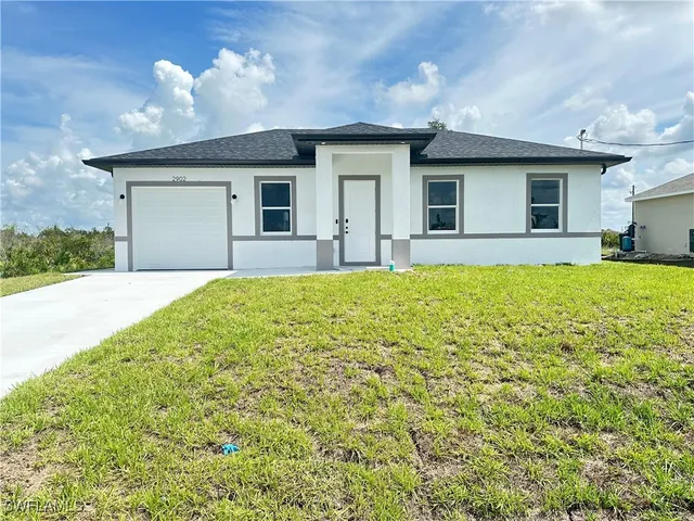a view of a house with a yard and pathway