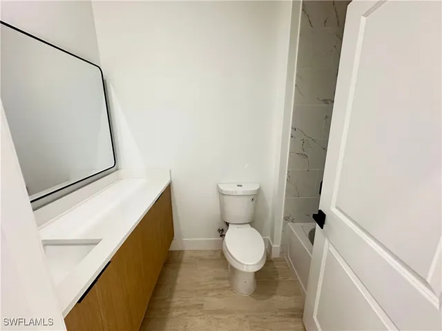 a white toilet sitting next to a shower