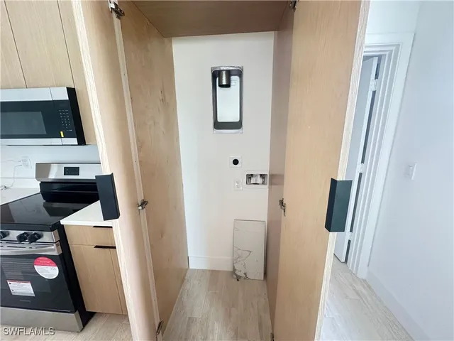 a view of a storage and utility room with wooden floor