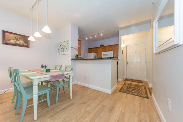 a view of a dining room with furniture a chandelier and wooden floor