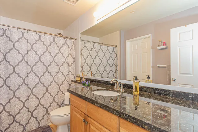 a bathroom with a granite countertop sink and a mirror