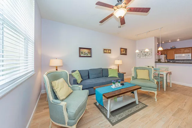 a living room with furniture a ceiling fan and a window