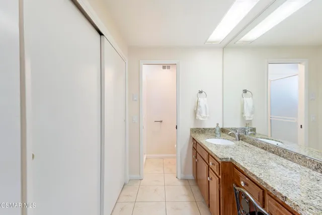 a spacious bathroom with a granite countertop sink and a mirror