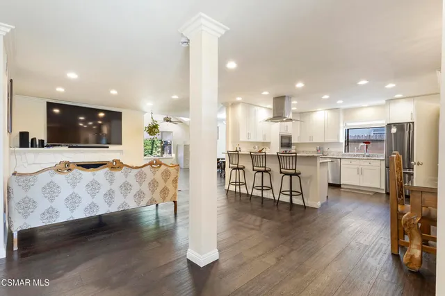 a living room with stainless steel appliances kitchen island granite countertop furniture and a view of kitchen