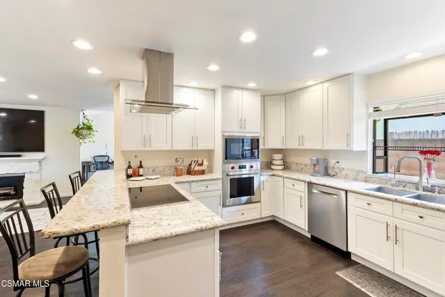 a kitchen with a sink white cabinets and stainless steel appliances