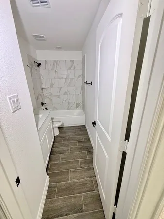 a view of a hallway with wooden floor and staircase