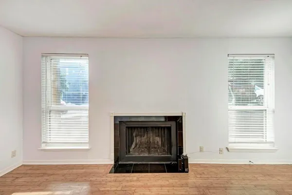 wooden floor fireplace and windows in an empty room