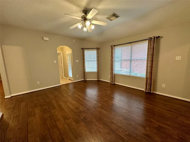 a view of an empty room and chandelier fan