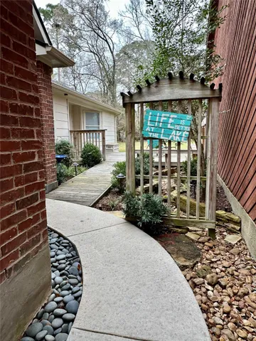 a view of a house with a small yard and a large tree