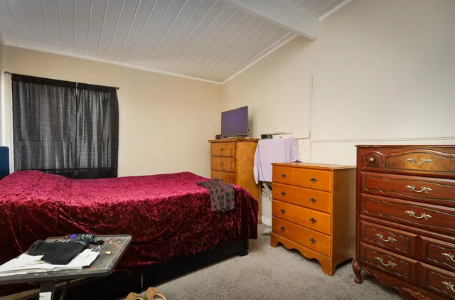 a bedroom with a bed and a dresser