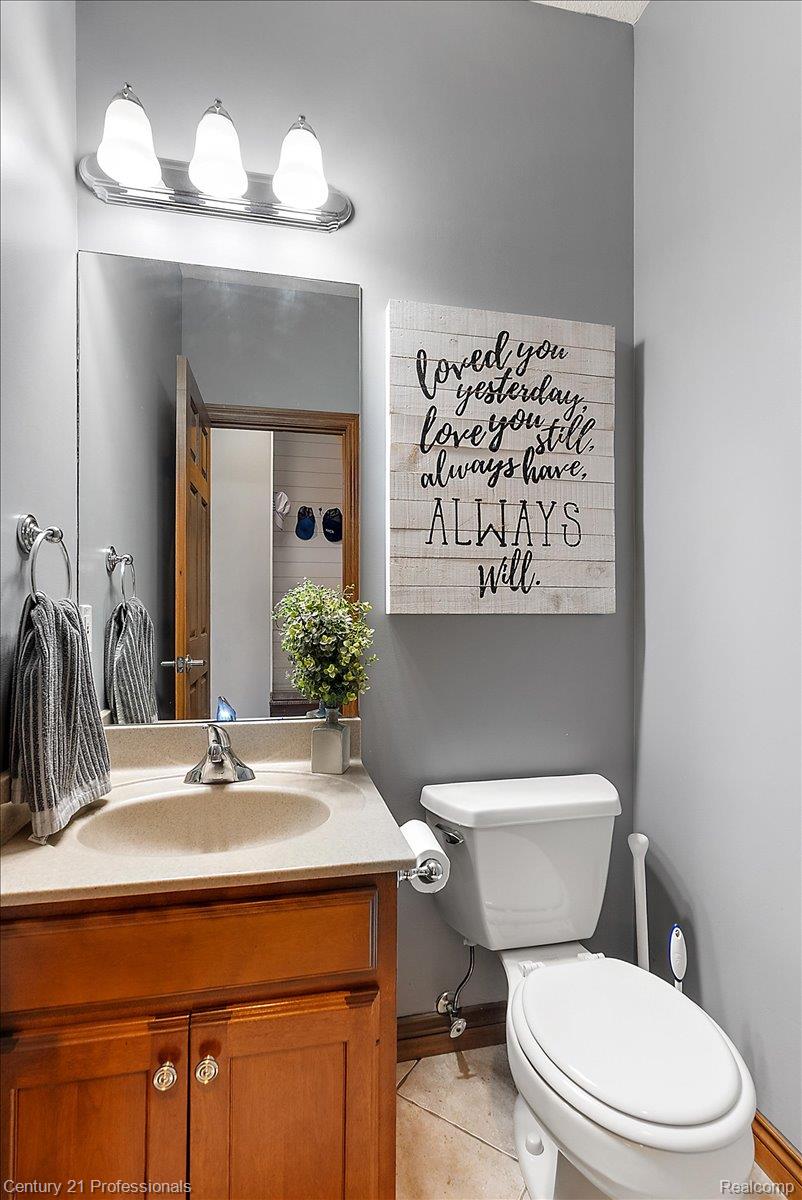 9867 Rainbow Ridge Drive Schoolcraft, MI 49087 - Photo 27 of 82 Bathroom vanity with a light-toned countertop, integrated sink, and wood-finish cabinetry