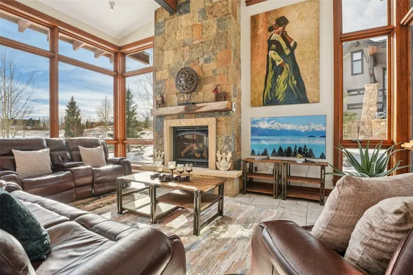 a living room with furniture a fireplace and a floor to ceiling window