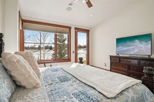 a bedroom with a bed and large windows